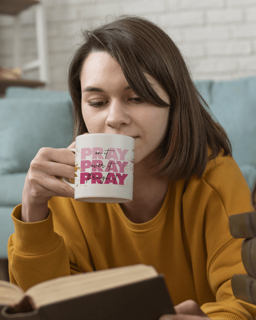 Young woman reading a book with 11oz Pray on it coffee mug